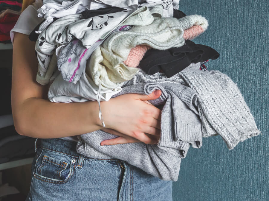 たくさんの洋服を抱えた女性